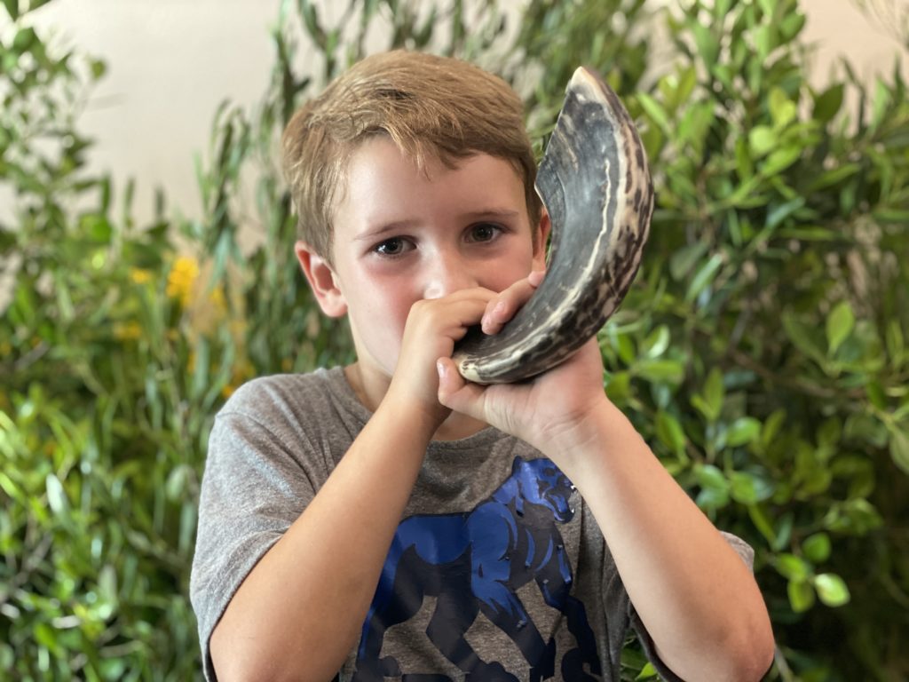 Boy blowing on a shofar